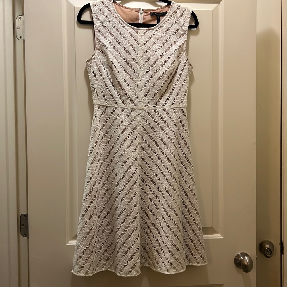 BCBG white sleeveless lace dress with beige under layer.